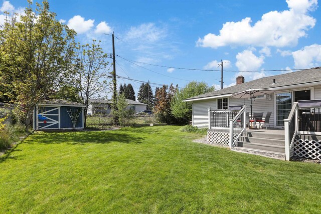 1007 S Bowdish Rd, Spokane Valley, WA 99206 - view of grassy yard with a storage shed, a deck, and an outdoor structure
