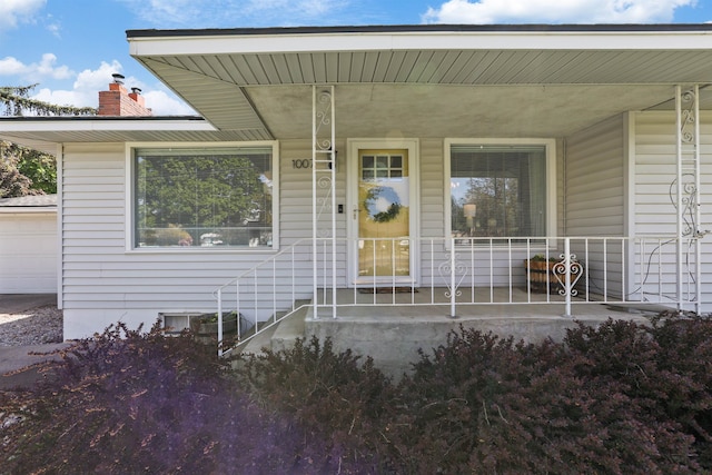1007 S Bowdish Rd, Spokane Valley, WA 99206 - view of exterior entry with a porch, a chimney, and a garage