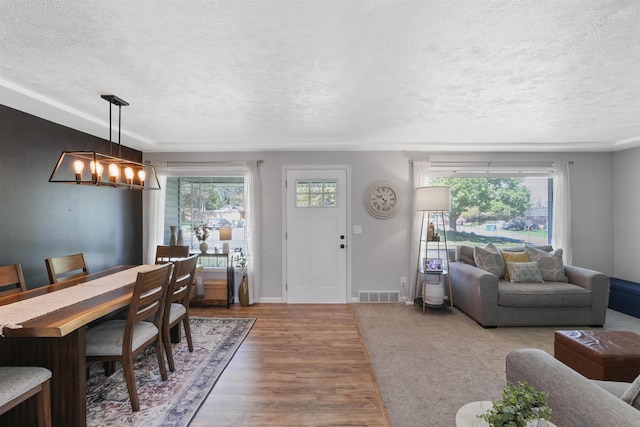 1007 S Bowdish Rd, Spokane Valley, WA 99206 - dining space featuring a textured ceiling, a chandelier, wood finished floors, and baseboards