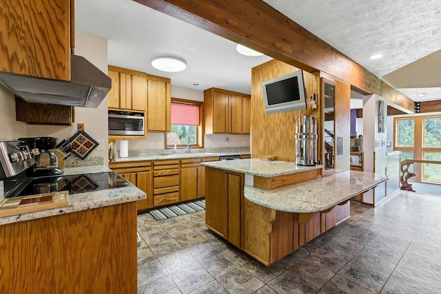 16615 W Stoughton Rd, Cheney, WA 99004 - kitchen featuring appliances with stainless steel finishes, range hood, plenty of natural light, and brown cabinetry