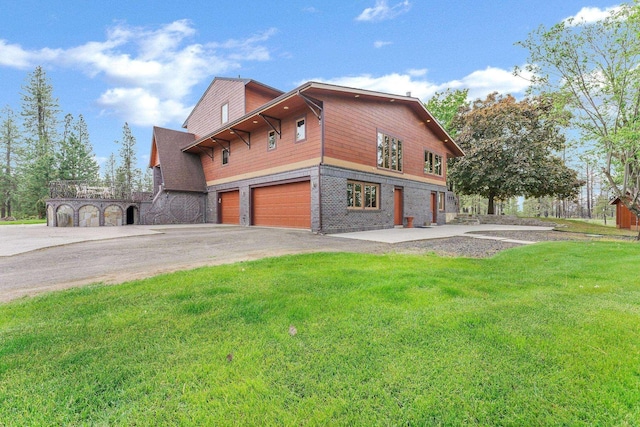 16615 W Stoughton Rd, Cheney, WA 99004 - view of side of home with driveway, a garage, a lawn, and brick siding