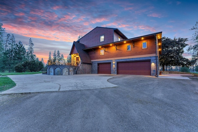 16615 W Stoughton Rd, Cheney, WA 99004 - view of front facade featuring asphalt driveway, stone siding, and an attached garage