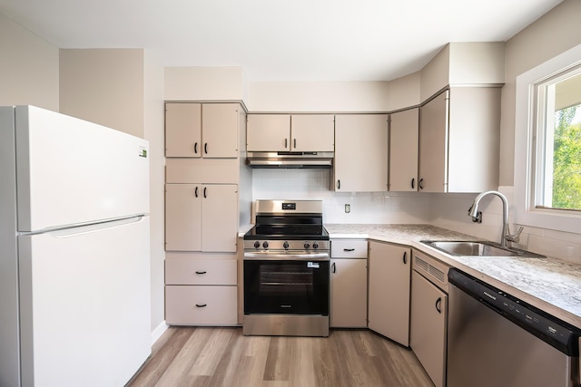 1715 N Jefferson St Unit 1717, Spokane, WA 99205 - kitchen featuring appliances with stainless steel finishes, a sink, light countertops, light wood-type flooring, and under cabinet range hood