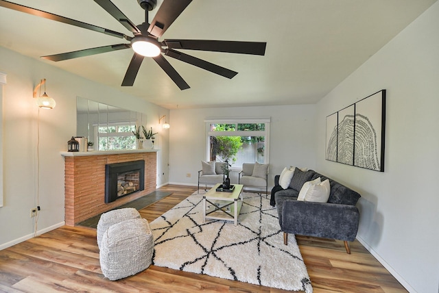 2033 S Rebecca St, Spokane, WA 99223 - living room featuring wood finished floors, ceiling fan, a brick fireplace, and baseboards