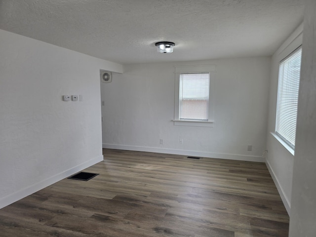 3019 E Augusta Ave, Spokane, WA 99207 - empty room with plenty of natural light, a textured ceiling, dark wood-style flooring, and baseboards