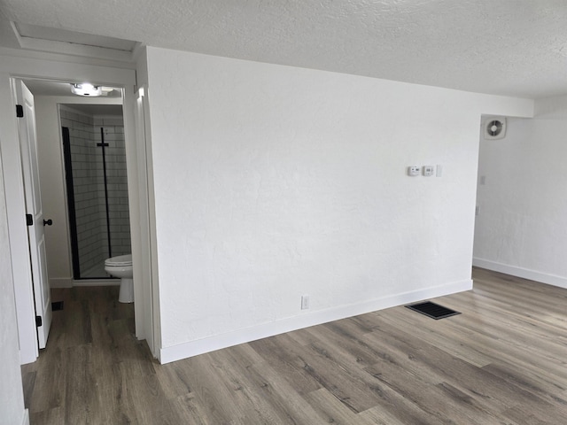 3019 E Augusta Ave, Spokane, WA 99207 - spare room with wood finished floors, a textured ceiling, and baseboards