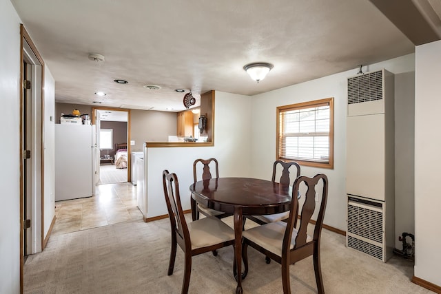 dining space with a heating unit, baseboards, light colored carpet, and recessed lighting