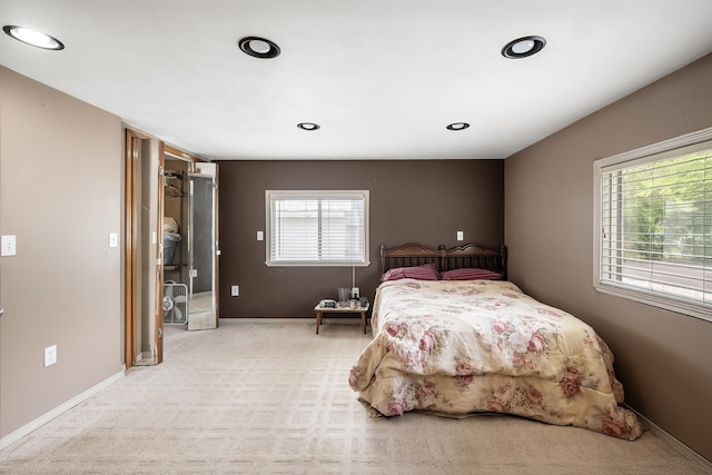 bedroom featuring light colored carpet, multiple windows, baseboards, and recessed lighting