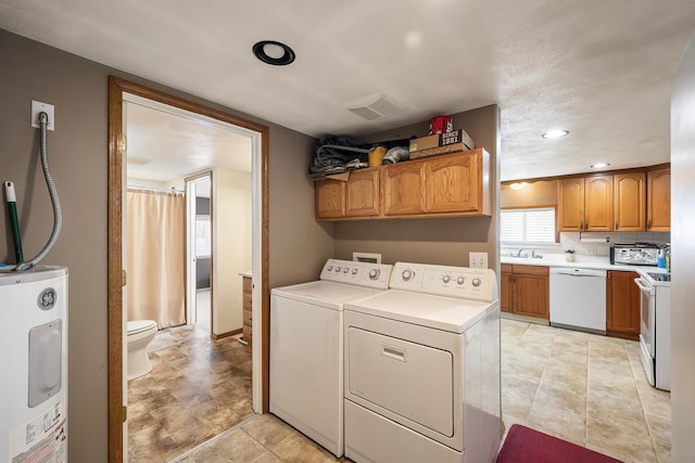 washroom with washer and dryer, water heater, and recessed lighting