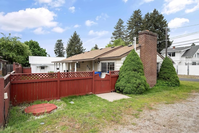 rear view of property with fence, a chimney, and a shingled roof
