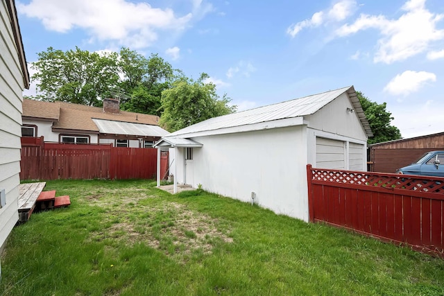 view of yard with a detached garage and an outdoor structure