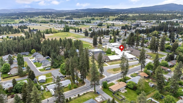 aerial overview of property's location with a mountainous background and nearby suburban area