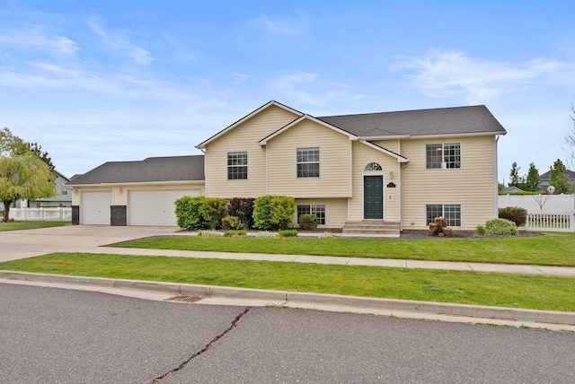 raised ranch with concrete driveway and a garage
