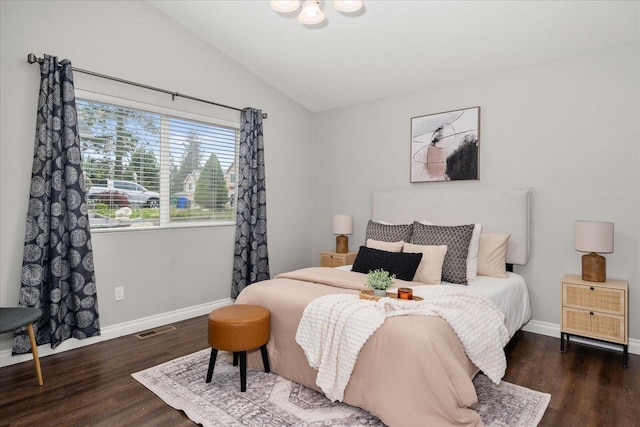 bedroom with vaulted ceiling, wood finished floors, and baseboards