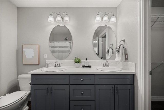 bathroom with toilet and double vanity