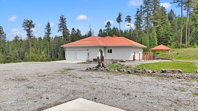 30915 N Chipmunk Rd, Chattaroy, WA 99003 - view of front of home featuring a gazebo, metal roof, a view of trees, and a chimney