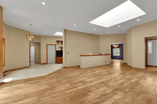 30915 N Chipmunk Rd, Chattaroy, WA 99003 - unfurnished living room featuring a chandelier, light wood-style floors, a skylight, baseboards, and recessed lighting