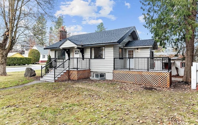 bungalow with roof with shingles, a front yard, and a chimney