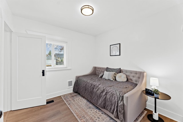 bedroom featuring baseboards and wood finished floors