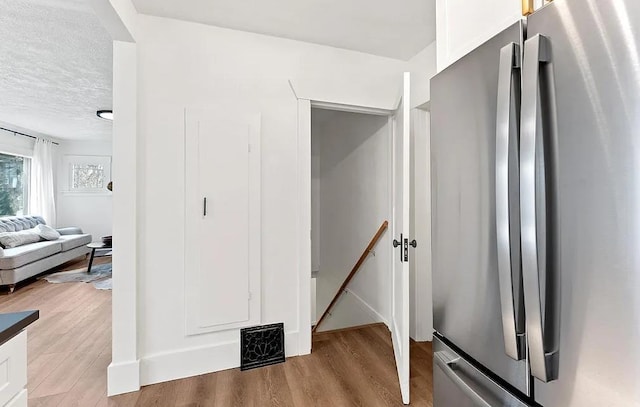 hallway featuring an upstairs landing and wood finished floors