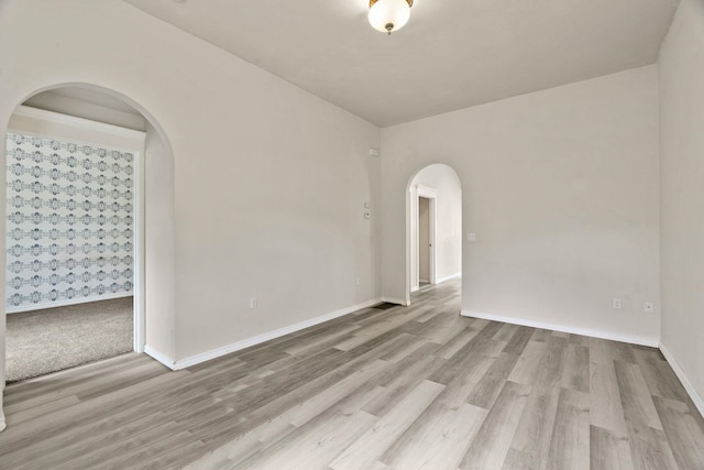 2212 W Gardner Ave, Spokane, WA 99201 - empty room with arched walkways, wood finished floors, and baseboards
