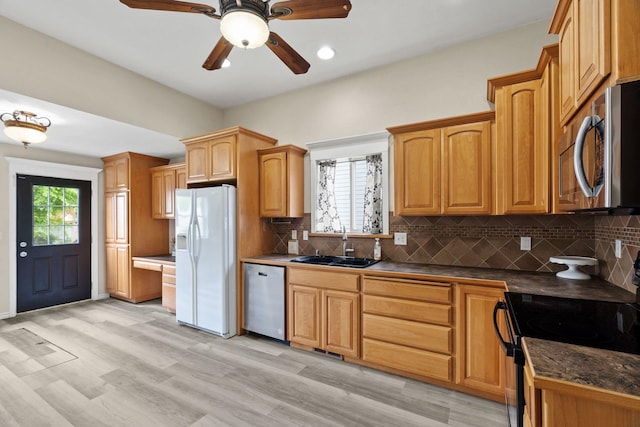 2212 W Gardner Ave, Spokane, WA 99201 - kitchen with appliances with stainless steel finishes, a sink, dark countertops, tasteful backsplash, and ceiling fan