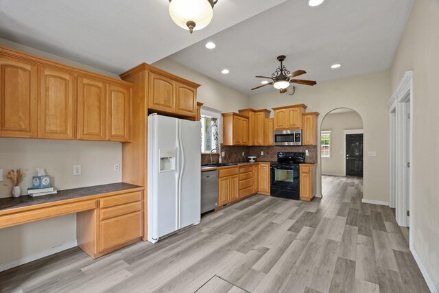 2212 W Gardner Ave, Spokane, WA 99201 - kitchen with stainless steel appliances, a ceiling fan, a sink, arched walkways, and light wood-style floors