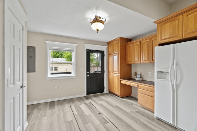 2212 W Gardner Ave, Spokane, WA 99201 - kitchen with white refrigerator with ice dispenser, light wood-style floors, electric panel, baseboards, and brown cabinets