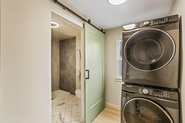 13513 E 12th Ave, Spokane Valley, WA 99216 - clothes washing area with stacked washer / dryer, a barn door, and baseboards