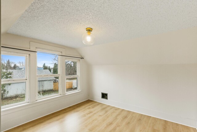 13513 E 12th Ave, Spokane Valley, WA 99216 - additional living space featuring plenty of natural light, light wood-type flooring, vaulted ceiling, a textured ceiling, and baseboards