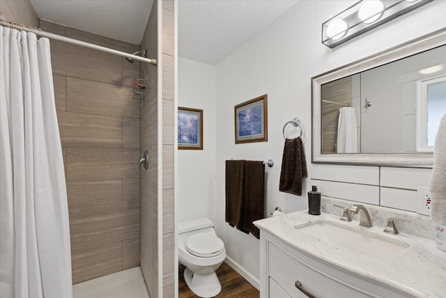 2311 W Wedgewood Ave, Spokane, WA 99208 - bathroom featuring toilet, tiled shower, vanity, and wood finished floors