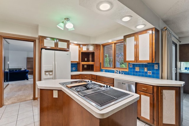 1610 E 35th Ave, Spokane, WA 99203 - kitchen featuring appliances with stainless steel finishes, a sink, light countertops, light colored carpet, and brown cabinetry