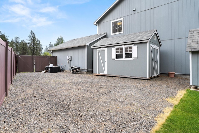 7421 W Lanzce Ct, Nine Mile Falls, WA 99026 - back of house with a gate, roof with shingles, a shed, an outbuilding, and fence