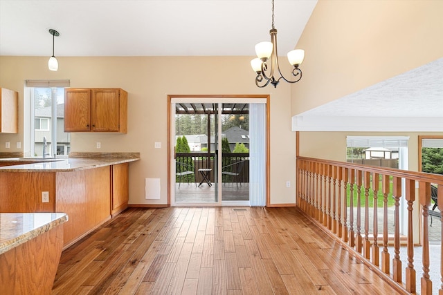 7421 W Lanzce Ct, Nine Mile Falls, WA 99026 - kitchen featuring light wood-style flooring, a chandelier, plenty of natural light, and brown cabinetry