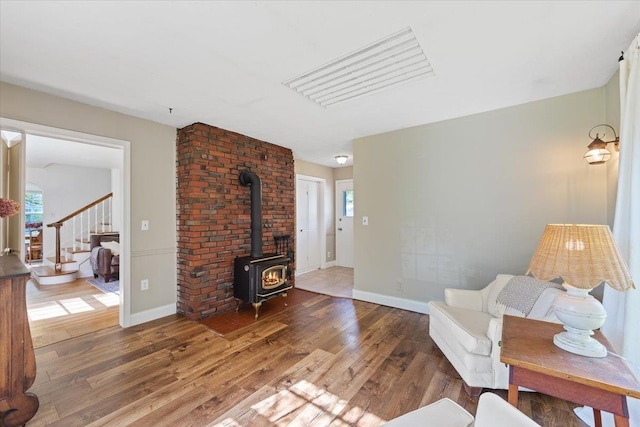 1421 N Sunderland Rd, Spokane Valley, WA 99206 - living area featuring wood finished floors, stairs, a wood stove, and plenty of natural light