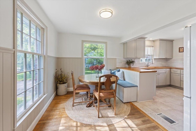 1421 N Sunderland Rd, Spokane Valley, WA 99206 - kitchen with butcher block counters, wainscoting, freestanding refrigerator, decorative backsplash, and a peninsula