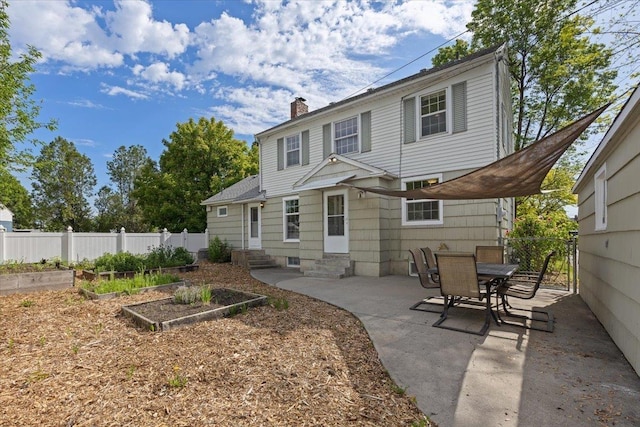 1421 N Sunderland Rd, Spokane Valley, WA 99206 - rear view of property with entry steps, a vegetable garden, a chimney, and a patio