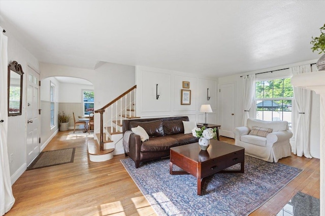 1421 N Sunderland Rd, Spokane Valley, WA 99206 - living room featuring arched walkways, healthy amount of natural light, light wood finished floors, and stairs