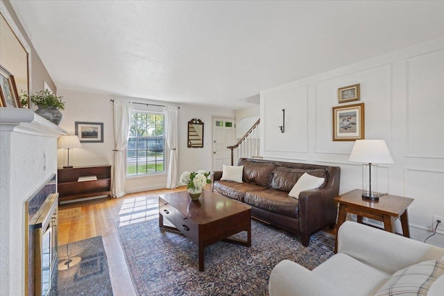 1421 N Sunderland Rd, Spokane Valley, WA 99206 - living room with stairs, a decorative wall, wood finished floors, and a fireplace