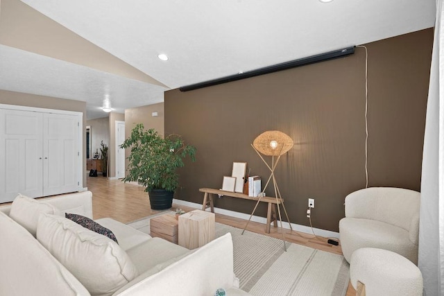 living area with wood finished floors, baseboards, vaulted ceiling, and recessed lighting