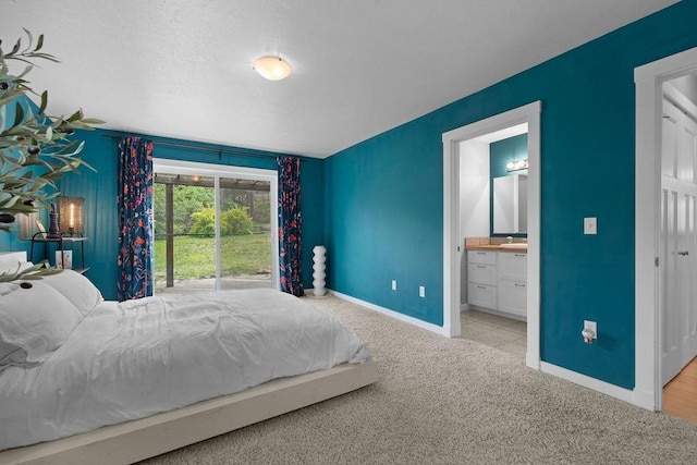 carpeted bedroom with baseboards and ensuite bath