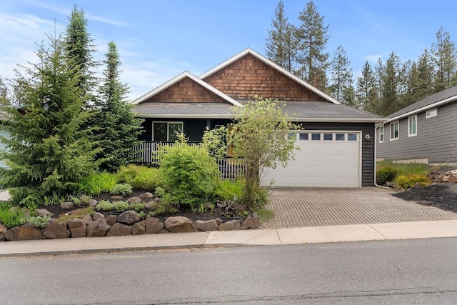 craftsman house with a garage, decorative driveway, and a shingled roof