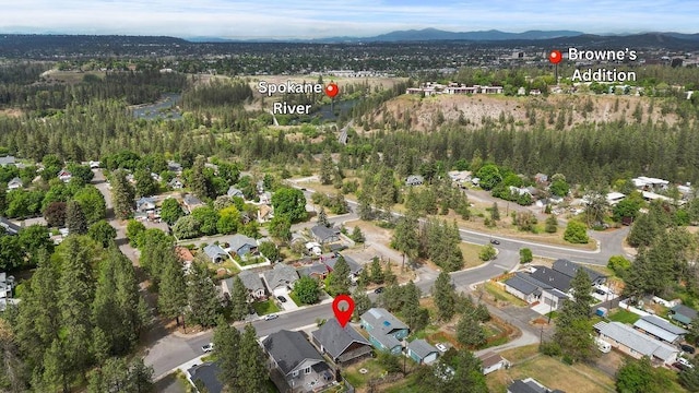 aerial view of property and surrounding area featuring a mountainous background and nearby suburban area