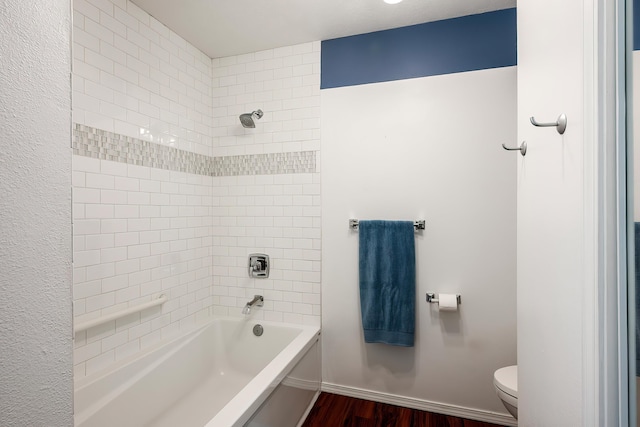 full bath featuring toilet, wood finished floors, and bathtub / shower combination
