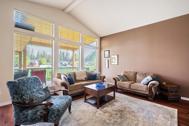 living area featuring healthy amount of natural light, wood finished floors, beam ceiling, baseboards, and high vaulted ceiling