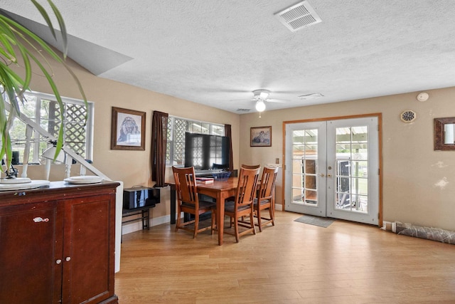 14203 E Belmont Rd, Mica, WA 99023 - dining room with french doors, light wood-type flooring, a textured ceiling, a ceiling fan, and baseboards