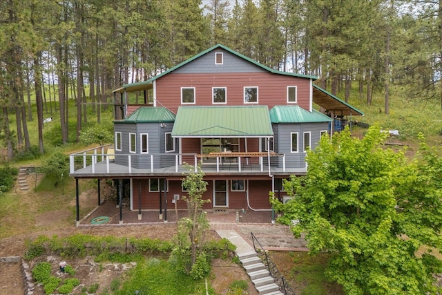 5217 E Stoughton Rd, Valleyford, WA 99036 - rear view of house featuring a deck, metal roof, and view of scattered trees