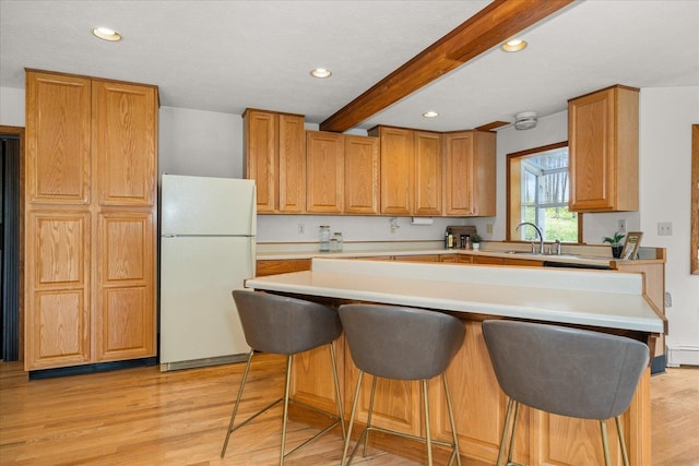 5217 E Stoughton Rd, Valleyford, WA 99036 - kitchen featuring freestanding refrigerator, a breakfast bar area, beamed ceiling, recessed lighting, and light wood finished floors