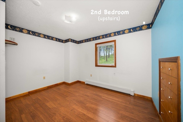 5217 E Stoughton Rd, Valleyford, WA 99036 - empty room with a baseboard heating unit, wood finished floors, and baseboards
