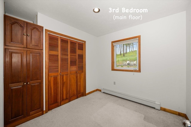 5217 E Stoughton Rd, Valleyford, WA 99036 - unfurnished bedroom with a baseboard heating unit, light carpet, a closet, and baseboards